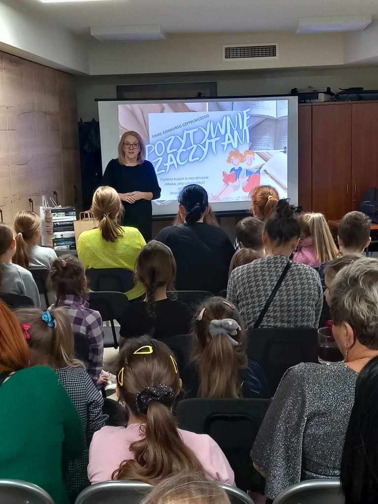 Kobieta stoi przed uczestnikami konkursu