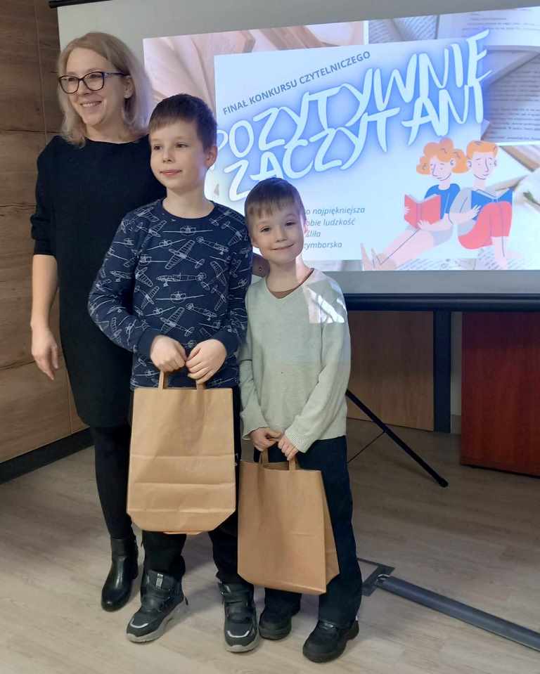 Kobieta wręcza nagrodę uczestnikowi konkursu