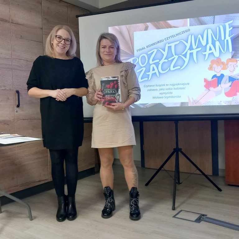 Kobieta wręcza nagrodę uczestnikowi konkursu