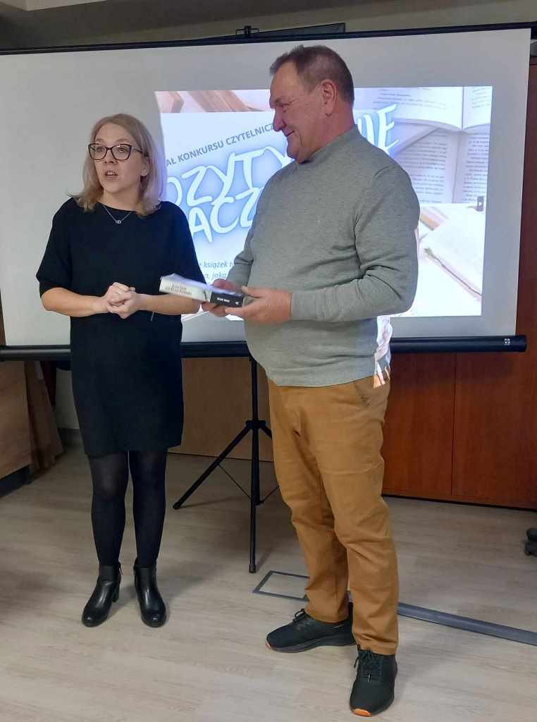 Kobieta wręcza nagrodę uczestnikowi konkursu